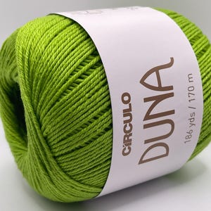 May include: A vibrant green ball of yarn with a white label wrapped around it. The label features the word "DUNA" in a brown font, along with the brand name "CIRCULO" and the measurement "186 yds / 170 m".