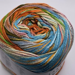 Puede incluir: Un ovillo de hilo multicolor con tonos de naranja, azul, verde y rosa. El hilo está hecho de algodón y es perfecto para tejer o hacer ganchillo.