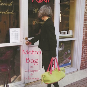 May include: A green and pink tote bag with the text "Metro Bag in 2 Shapes & Colorways" and "by Laura J. Bellows".