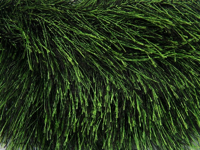 May include: A close-up of a green, fluffy garland made of thin, wispy strands. The garland is perfect for adding a touch of greenery to any space.