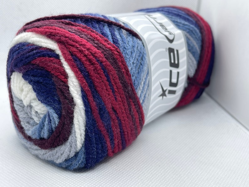 May include: A ball of yarn with a white, gray, blue, and burgundy color pattern. The yarn is labeled "ICE Yarn".