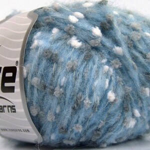 May include: A ball of Ice Yarns brand yarn in a light blue color with flecks of white and gray. The yarn has a textured, speckled appearance. The label features the brand name "Ice Yarns" and a star logo.