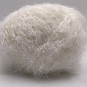 May include: A ball of soft, white yarn. The yarn has a fluffy, textured appearance, with long, delicate fibres. This yarn is likely used for knitting or crocheting projects, ideal for creating cosy garments or accessories.