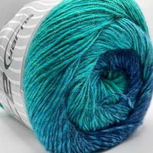 May include: A close-up of a skein of yarn in shades of teal and blue. The yarn is tightly wound, revealing the texture of the fibers. The label on the side reads "yarns".