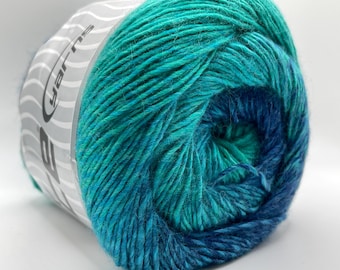 Könnte beinhalten: Nahaufnahme eines Garnknäuels in Türkis- und Blautönen. Das Garn ist eng gewickelt und zeigt die Textur der Fasern. Das Etikett auf der Seite lautet "yarns".