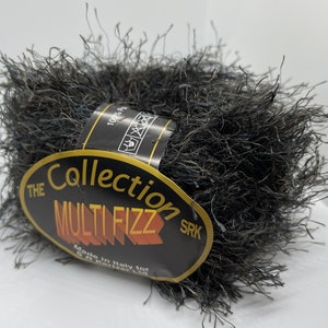 Peut inclure: Une pelote de fil noir et duveteux avec une étiquette qui indique "The Collection Multi Fizz SRK Made in Italy for S.K. Kenzar Ltd."