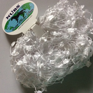 Könnte beinhalten: Weißes, flauschiges Garn mit einem Etikett mit der Aufschrift "NUBS" Dark Horse Yarn www.darkhorseyarn.com