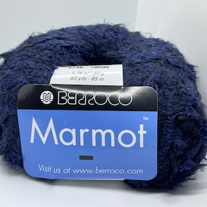 Może przedstawiać: Motka niebiesko-granatowej przędzy o nazwie "Marmot" firmy Berroco. Etykieta podaje 1,75 uncji lub 50 g, 93 jardy - 85 m. Przędza jest puszysta i ma fakturowany wygląd.