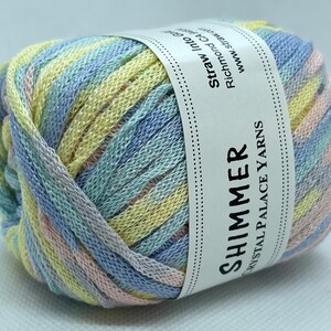 May include: A ball of Shimmer Crystal Palace Yarns in pastel colors. The yarn is a blend of yellow, blue, pink, and silver. The label reads "Shimmer" and "Crystal Palace Yarns". The yarn is suitable for knitting and crochet projects.