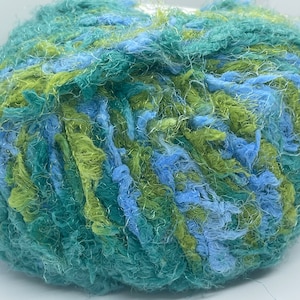 May include: A ball of yarn in shades of green and blue. The yarn is a fuzzy, textured type.