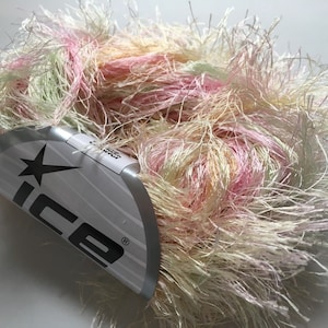 May include: A skein of soft, fluffy yarn in shades of pink, green, and white. The yarn is labeled "Ice" with a star logo.