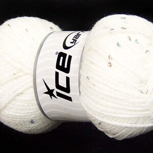 May include: Two balls of white yarn with silver sequins. The yarn is packaged with a white label that says "Ice Yarns" in black letters.
