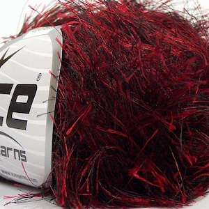 May include: A ball of ICE Yarns brand yarn, featuring a blend of red and black fibers. The yarn has a fuzzy, textured appearance. The label is white with the brand name and logo.