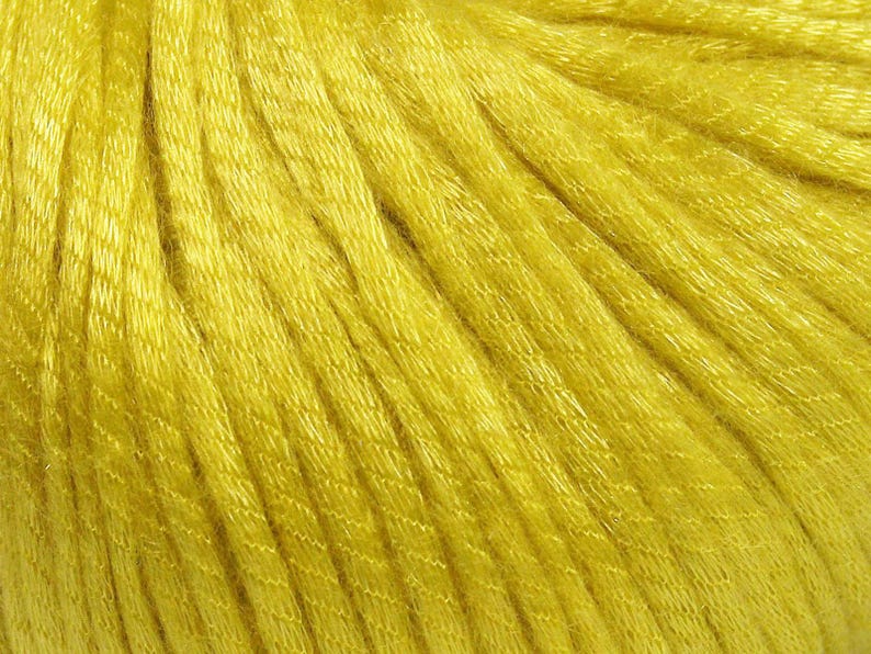 May include: A vibrant yellow yarn featuring a multi-ply twisted construction with a distinct sheen. The individual strands are tightly wound together, creating a smooth, uniform texture across the entire surface of the fiber material.