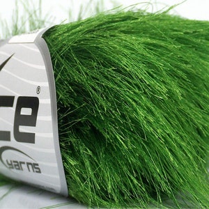 Pode incluir: Um novelo de fio verde brilhante e felpudo com um rótulo que diz "Ice Yarns".