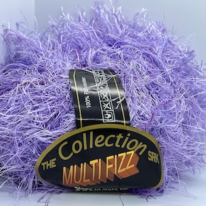 Peut inclure: Un peloton de fil pelucheux lavande et blanc avec une étiquette indiquant "The Collection Multi Fizz SRK 100% Polyester".