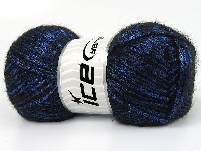 May include: A skein of black and blue yarn with a silver shimmer. The yarn is wrapped around a white label with the text "Ice Yarn" in black.