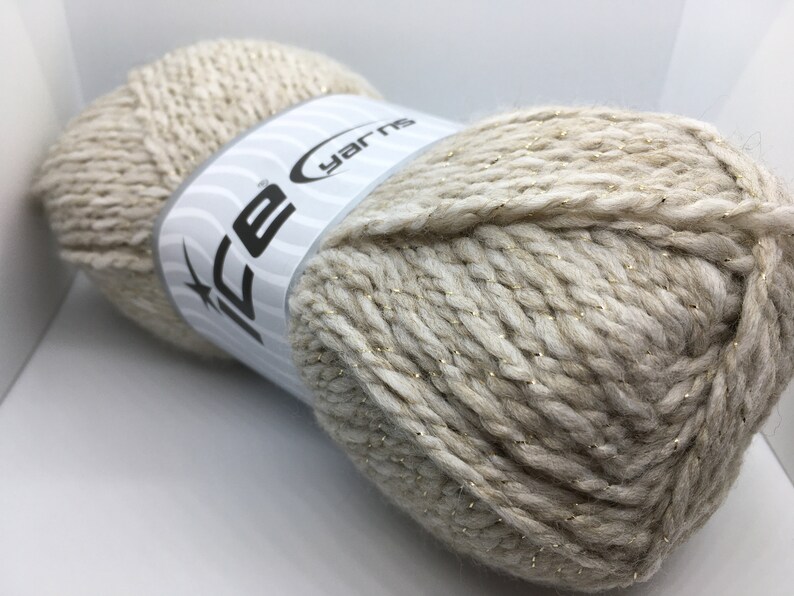May include: A skein of beige yarn with gold glitter thread. The yarn is labeled "Ice Yarns".