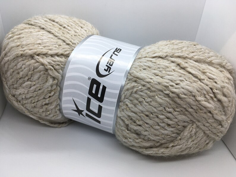 May include: A skein of beige yarn with gold thread running through it. The yarn is labeled "Ice Yarns".