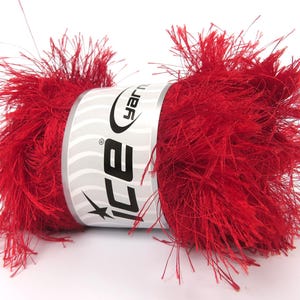 May include: A vibrant red yarn ball with a fluffy, textured appearance. The yarn is wrapped around a white label with the "ice yarn" logo. This yarn is suitable for various crafting projects, such as knitting or crocheting.