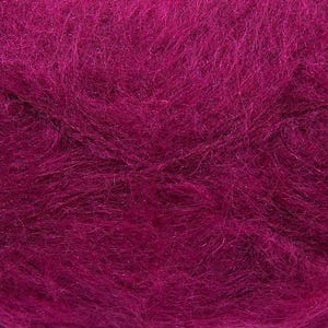 May include: Close-up of a vibrant magenta yarn, showcasing a soft, textured appearance. The yarn fibers are densely packed, creating a plush, inviting look. This yarn is suitable for various knitting and crochet projects.