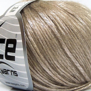 May include: A ball of beige yarn with a silver shimmer, labeled "Ice Yarns" with a star logo. The label also says "Rock Star".