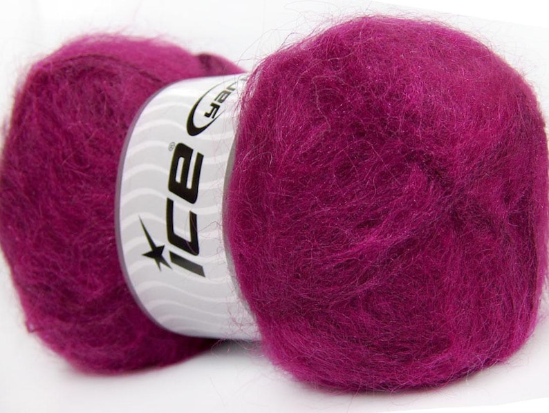 May include: A close-up of a skein of vibrant magenta yarn. The yarn is fluffy and soft, with a slight sheen. The label on the yarn reads "ice" in a stylized font. This yarn is perfect for knitting and crocheting projects.