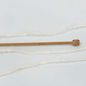 May include: A skein of white yarn with a wooden knitting needle, marked 4.0 mm.
