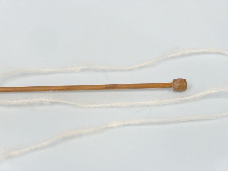 May include: A skein of white yarn with a wooden knitting needle, marked 4.0 mm.