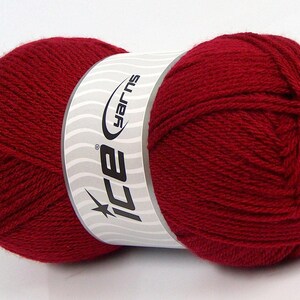Puede incluir: Una madeja de hilo rojo intenso con una etiqueta blanca con el logotipo "ice yarns". El hilo está bien enrollado, mostrando la textura de las fibras. Ideal para proyectos de punto y ganchillo.
