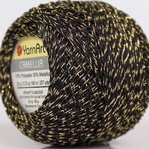 May include: A ball of black yarn with gold metallic thread. The label reads "YarnArt Camelia 70% Polyester 30% Metallic 20 g / 1.70 oz 190 m / 207 yds".