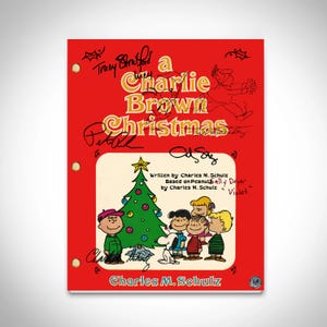 Puede incluir: Una portada roja con el título "a Charlie Brown Christmas" en letras amarillas. La portada presenta ilustraciones de Charlie Brown, un árbol de Navidad y otros personajes. El nombre del autor, Charles M. Schulz, está en la parte inferior.