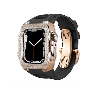May include: Rose gold Apple Watch case with a black band. The case is encrusted with small, clear crystals around the watch face. The watch band is black rubber with a rose gold clasp.