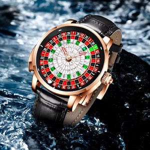 May include: A gold-tone wristwatch with a black leather band. The watch face features a roulette wheel design with red and green accents and a diamond-like pattern in the center.