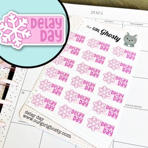 May include: A sheet of planner stickers featuring a pink snowflake design with the words "Delay Day." The stickers are rectangular with a light pink background and a white snowflake. The website address www.ourgirlghosty.com is visible.