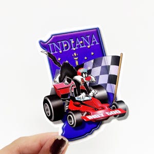 May include: A sticker featuring a cartoon black cat driving a red race car with the words "Indy 500" on the side. The car is driving on a blue background with a white outline of the state of Indiana and the word "INDIANA" in white letters.