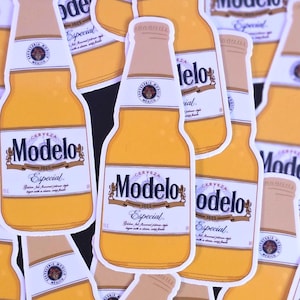 May include: A collection of Modelo Especial beer bottle stickers. The stickers feature a yellow bottle design with a tan cap and a white label with the brand name and logo. The stickers are scattered across the image.