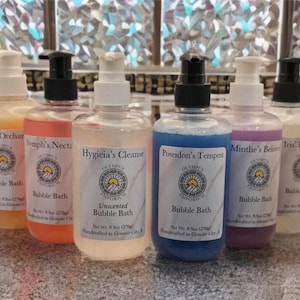 May include: Six bottles of bubble bath with different scents and colors. The bottles are labeled with the names of Greek gods and goddesses. The bottles are 9.5 ounces each and are handcrafted in Granite City.