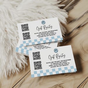Puede incluir: Tarjetas blancas de registro de regalos con un borde a cuadros azul y un icono de cara sonriente. Las tarjetas tienen un código QR y el texto "Gift Registry" e instrucciones.