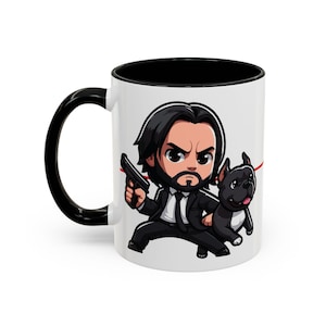 May include: White ceramic coffee mug with a black handle and black rim. The mug features a cartoon illustration of John Wick with a gun and his dog.
