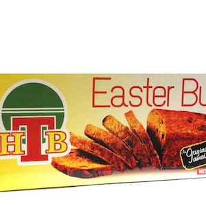 Puede incluir: Una caja amarilla con un círculo verde que contiene las letras "HTB" en rojo. La caja tiene una imagen de pan de Pascua cortado y el texto "Easter Bun" en rojo. El texto "The Original Jamaican Product" está en un cuadro blanco con borde rojo y una bandera jamaicana.