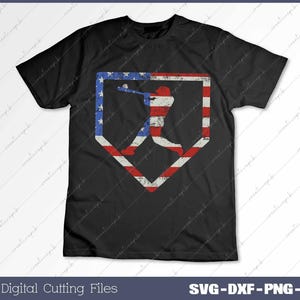 Pode incluir: Uma camiseta preta com um design de bandeira americana desbotada que apresenta um jogador de beisebol em uma silhueta de home plate.