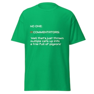 May include: Green t-shirt with white text that reads "NO ONE: F1 COMMENTATORS: 'Well that's just thrown multiple cats up into a tree full of pigeons'".