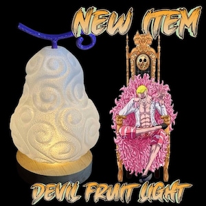 May include: A white, pear-shaped night light with a blue stem and a wooden base. The light is shaped like a Devil Fruit from the anime One Piece. The text "NEW ITEM" and "DEVIL FRUIT LIGHT" are visible in the image.