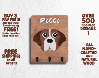 May include: Wooden key holder with a brown dog face illustration and the name "ROCCO" in white lettering. The key holder has three hooks for hanging keys.