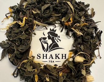 May include: Loose leaf tea with dried green leaves and yellow flower petals arranged around a white square. The square features a black silhouette of a woman drinking tea, with the text "SHAKH TEA".