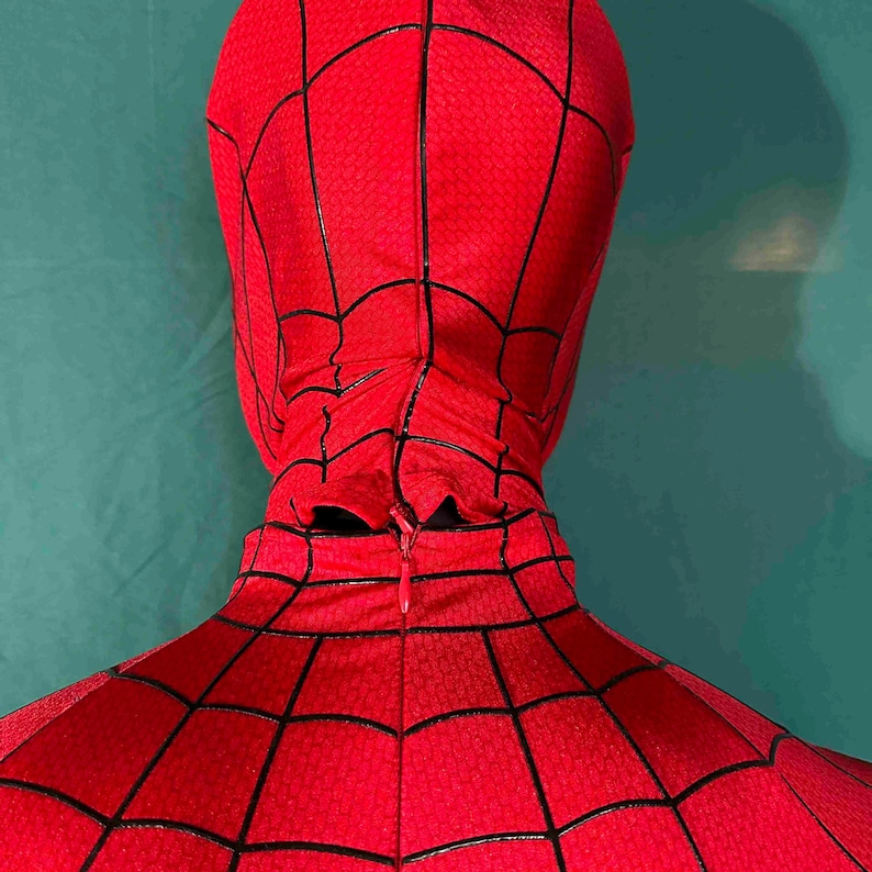 Puede incluir: Disfraz de Spider-Man rojo y negro, con un patr&oacute;n texturizado y detalles de telara&ntilde;a negros. El disfraz incluye una capucha y una cremallera en la espalda. El dise&ntilde;o general es rojo vibrante con l&iacute;neas negras.