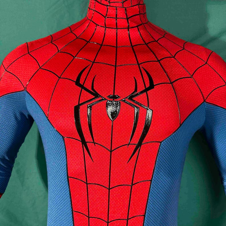 Puede incluir: Un disfraz de Spider-Man rojo y azul. Las secciones rojas presentan un patr&oacute;n de telara&ntilde;a y el emblema de la ara&ntilde;a negra est&aacute; centrado en el pecho. Las secciones azules est&aacute;n en los brazos y los lados. El disfraz tiene un cuello alto.