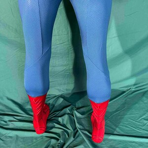 Puede incluir: Mallas de disfraz de superh&eacute;roe azules y rojas. Las mallas son de un azul vibrante con un patr&oacute;n texturizado. Los pies son rojos con un dise&ntilde;o similar a una telara&ntilde;a, creando un look de superh&eacute;roe.