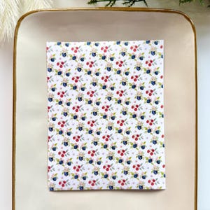 May include: A handmade wooden sign with the text "Welcome" in a playful font. The sign is painted white with a distressed finish, and features a decorative floral design in shades of pink and green. It measures approximately 12 inches wide.